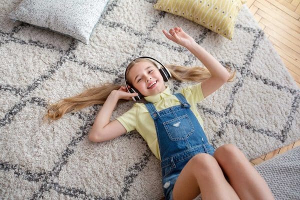 Teenage girl lying on clean carpet